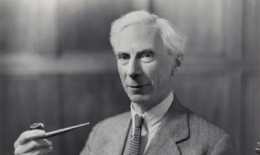 Image shows a black-and-white photo of Bertrand Russell holding a pipe.