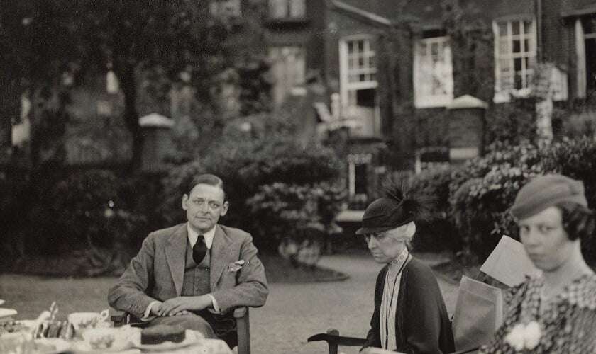 Image shows TS Eliot and two women in the garden of a grand house.