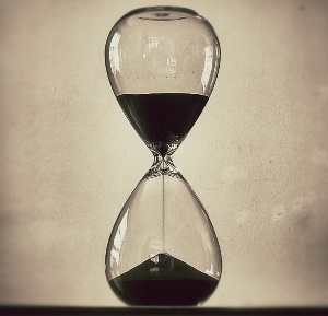 Image shows sand falling through an hourglass.