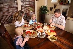 Image shows a typical family sitting around a dinner table.