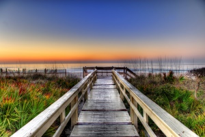 Image shows sunrise over a boardwalk.