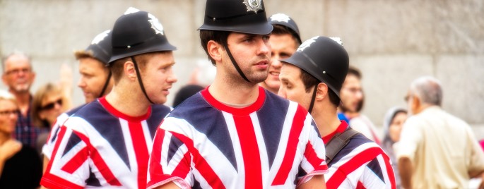 Image shows a group of men wearing Union Jack t-shirts and police helmets.