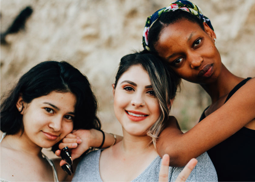 Trois adolescentes se penchant l'une sur l'autre.